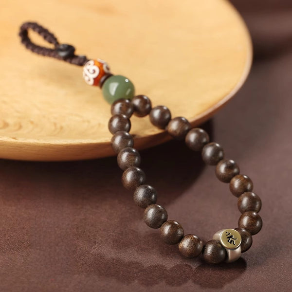 Hetian Jade & Agarwood Zodiac Buddha Keychain – Dark agarwood beads with green Hetian jade, Dzi-pattern bead, and Sanskrit metal plate on wood