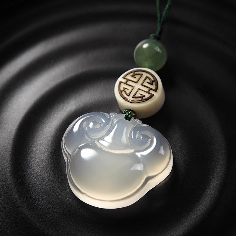 Chalcedony Ruyi Keychain – detailed close-up of ruyi pendant on black ripple ceramic plate