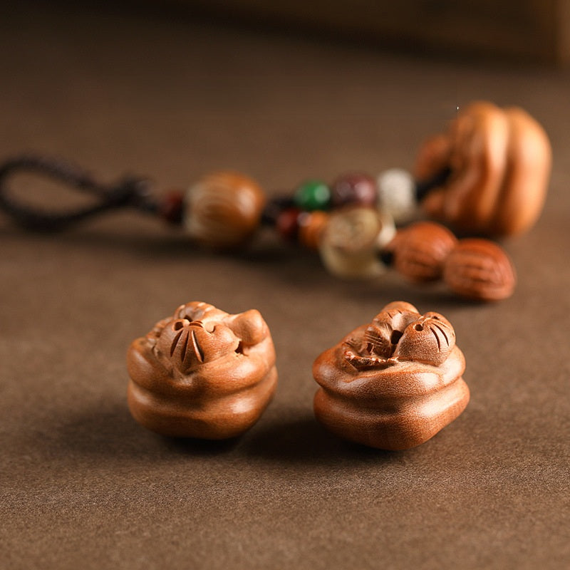 Close-up detail of hand-carved peach wood persimmon pendants with natural wood grain