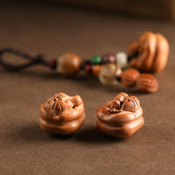 Close-up detail of hand-carved peach wood persimmon pendants with natural wood grain