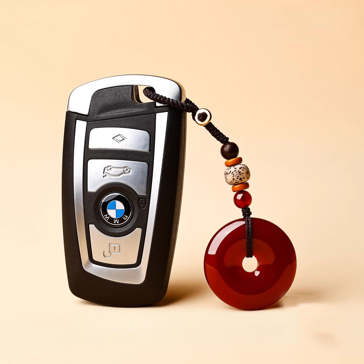 Jade Keychain Pendant – Red-brown jade donut attached to BMW car key with brown cord, practical car accessory