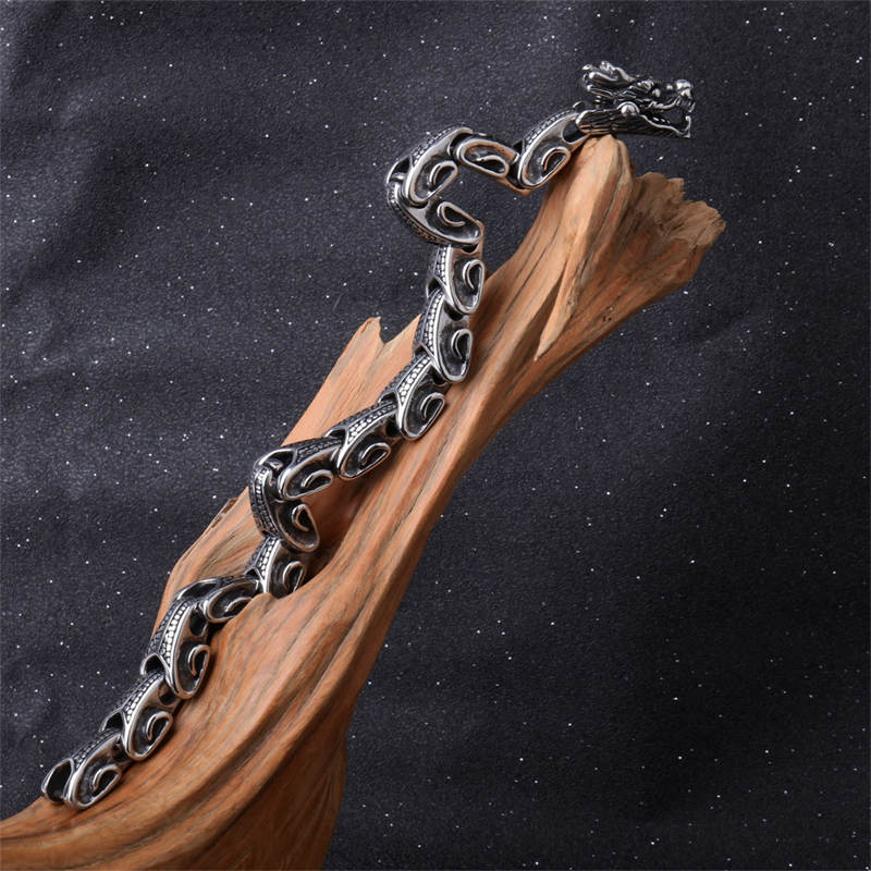 Dragon Titanium Steel Luck Bracelet Bangle - open C-shape on driftwood with starfield background, gothic aesthetic