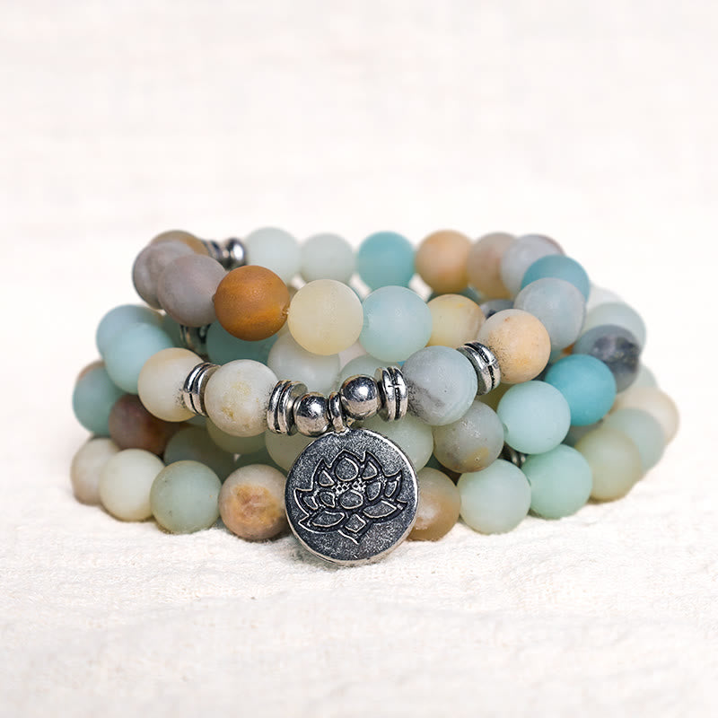Amazonite Lotus Mala – triple-strand stretch bracelet on white fabric with lotus detail, amazonite