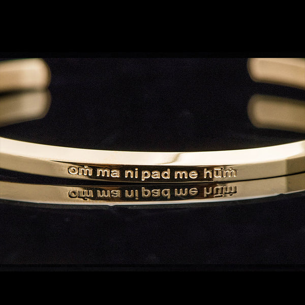 Om Mani Padme Hum Engraved Bracelet – macro detail of Sanskrit mantra with diacritical marks, gold cuff
