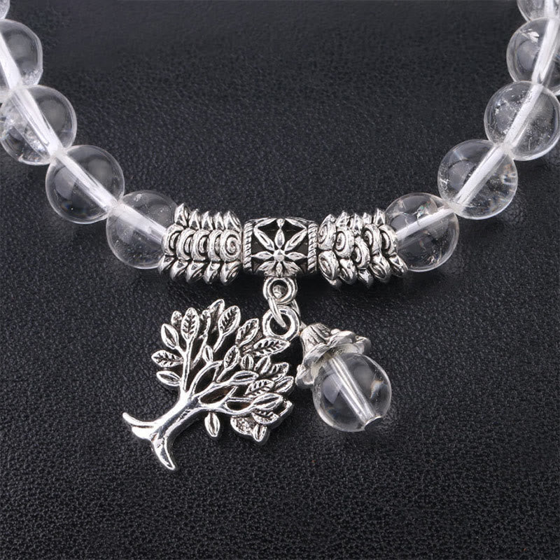 Tree of Life clear quartz bracelet with rock crystal beads, silver tree-of-life charm, small quartz teardrop dangle accent.