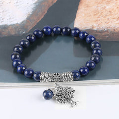 Tree of Life lapis lazuli bracelet with deep blue gold-flecked beads, ornate silver spacer bead, tree of life charm with blue bead dangle.