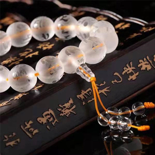 White Crystal Om Mani Padme Hum Bracelet – macro close-up on gold calligraphy surface, quartz mala