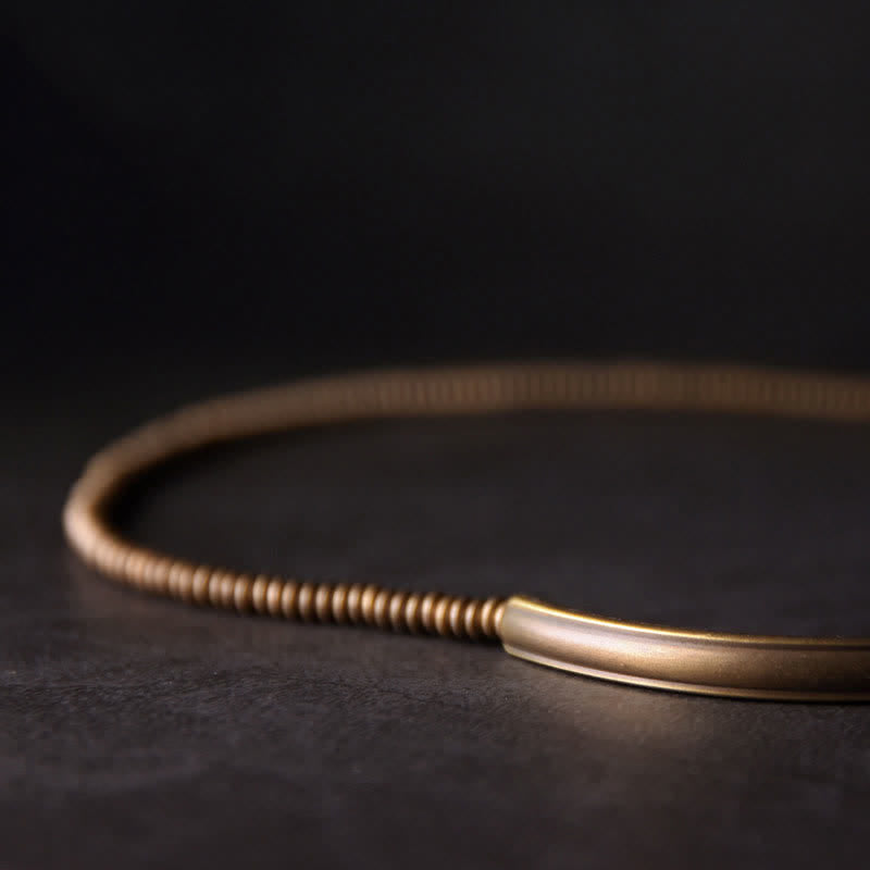 Lava Rock Copper Healing Bracelet – Volcanic black beads with copper wire-wrapped center on light gray textured stone, overhead flat lay product photo