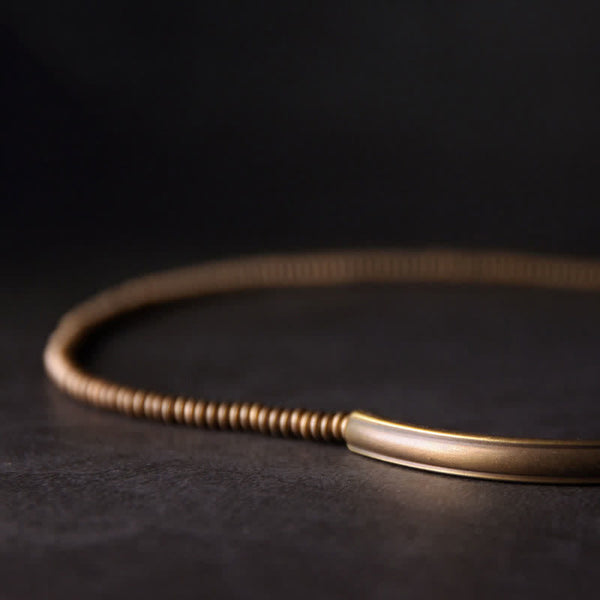 Lava Rock Copper Healing Bracelet – Volcanic black beads with copper wire-wrapped center on light gray textured stone, overhead flat lay product photo