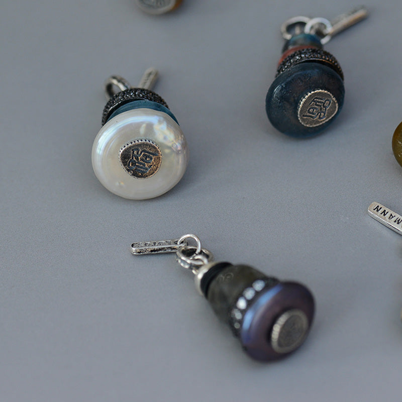 Zen Cairn Crystal Pendant – three button-style charm pendants with pearl teal purple faces, artisan charms