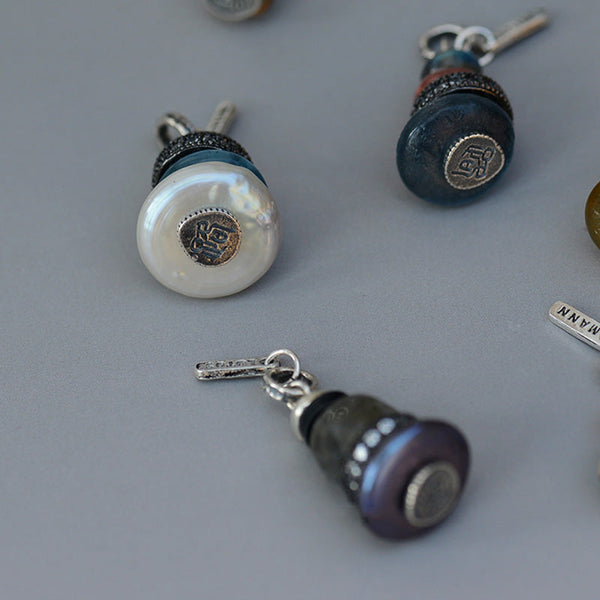 Zen Cairn Crystal Pendant – three button-style charm pendants with pearl teal purple faces, artisan charms