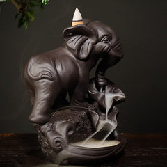 Baby Elephant Incense Burner – Side angle with playful raised leg pose and flowing smoke on lotus leaf base, zen decor