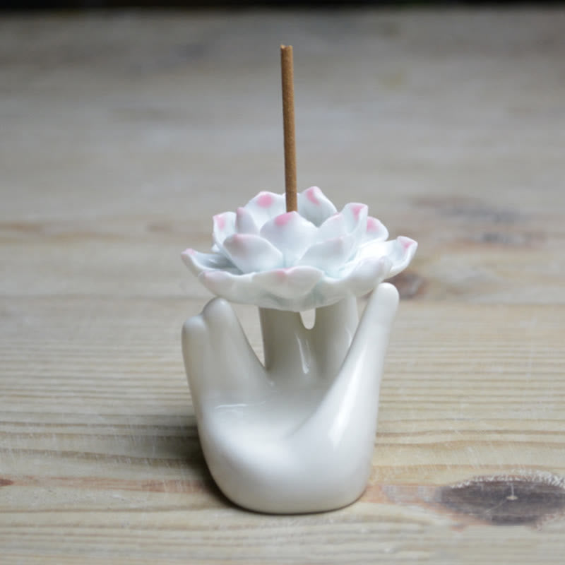 Ceramic Lotus Hand Incense Burner - cupped hand with pink lotus on light wood, meditation decor
