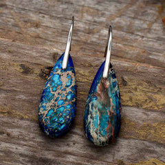 Emperor Stone Healing Crystal Earrings – Pair of teardrop imperial jasper earrings with blue green matrix patterns on weathered wood background