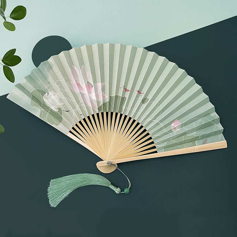 Lotus Koi Fish Folding Fan - angled open view with matching green tassel and leaf prop, tranquil