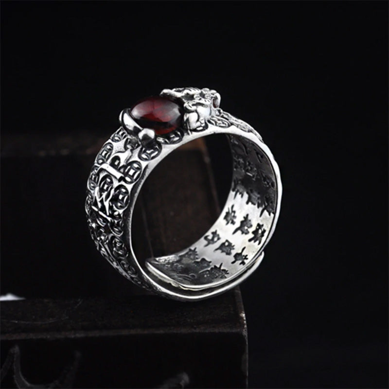 PiXiu Red Garnet Wealth Ring – Angled view of PiXiu figure atop red garnet gemstone, wealth coin pattern
