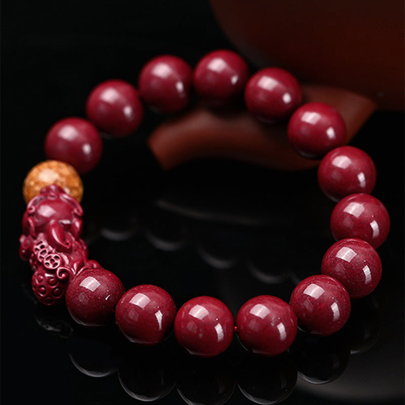 Tibetan Cinnabar PiXiu Bracelet – Close-up angled view on black reflective surface, carved PiXiu detail