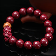 Tibetan Cinnabar PiXiu Bracelet – Close-up angled view on black reflective surface, carved PiXiu detail
