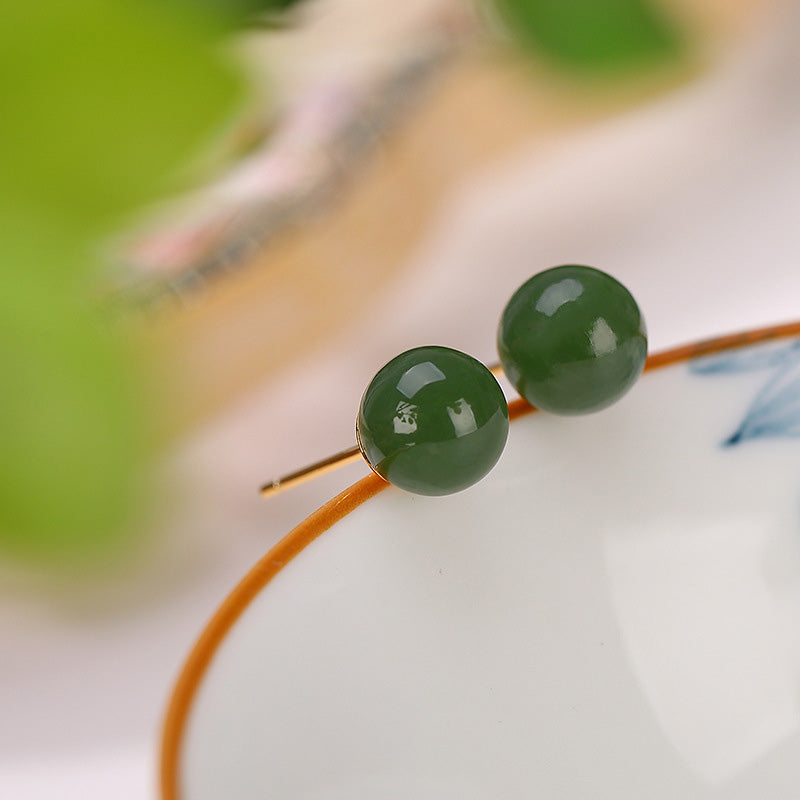 925 Silver Cyan Jade Healing Stud Earrings – forest green jade beads on natural branch, outdoor bokeh, organic product display