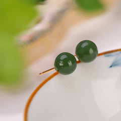 925 Silver Cyan Jade Healing Stud Earrings – forest green jade beads on natural branch, outdoor bokeh, organic product display