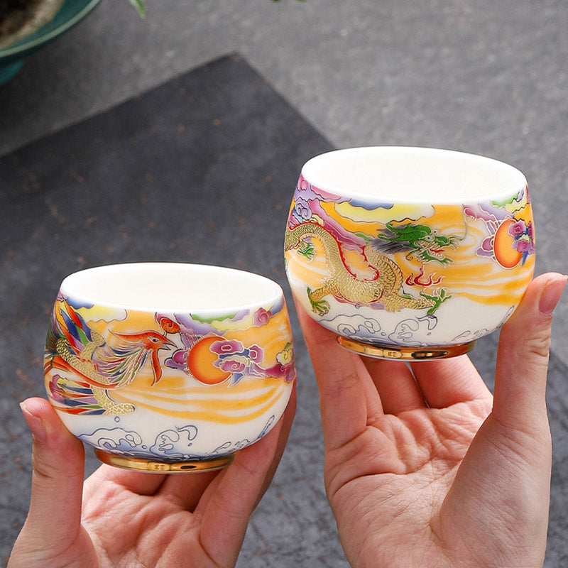Dragon Phoenix Ceramic Teacup - Matching dragon and phoenix pair held in cupped hands, harmony
