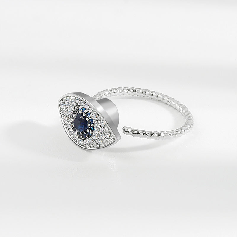 Evil Eye Rotatable Ring – Silver adjustable ring with blue sapphire center, crystal pave halo, rope band