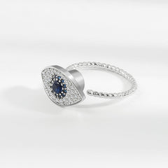 Evil Eye Rotatable Ring – Silver adjustable ring with blue sapphire center, crystal pave halo, rope band