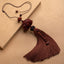 Red Sandalwood Lotus Tassel - carved lotus with silk tassel on kraft paper, diagonal drape