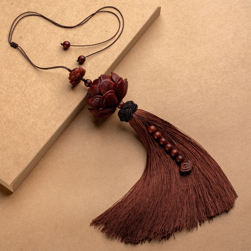 Red Sandalwood Lotus Tassel - carved lotus with silk tassel on kraft paper, diagonal drape