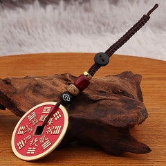 Shan Gui Keychain – red coin charm with gold border on brown cloud cord, driftwood display base