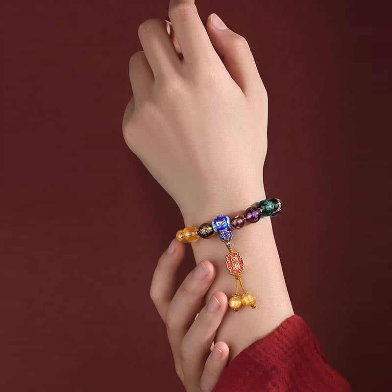 Tibetan Liuli Wrist Mala – Colorful mala bracelet on wrist with gold dangle beads and red charm