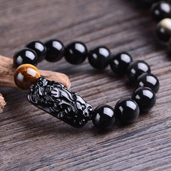 Black Obsidian PiXiu Tiger Eye Bracelet on driftwood prop, rectangular carved charm, strength talisman jewelry