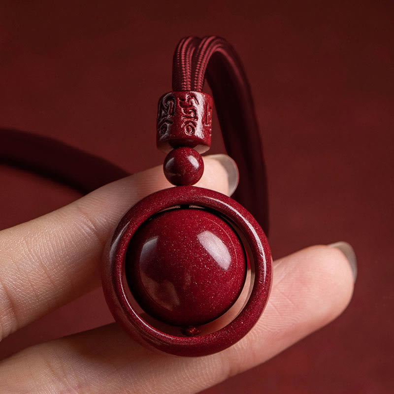 Cinnabar PiXiu Necklace – Fingers holding pendant close-up red cord and mantra bead detail, blessing pendant