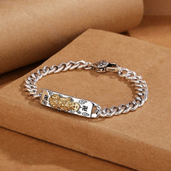 Om Mani Padme Hum PiXiu Swastika Wisdom Bracelet – silver bracelet on stacked brown boxes, lifestyle product shot
