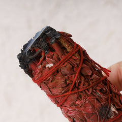 Dragon's Blood sage smudge – burned red bundle with charred tip close-up, grounding