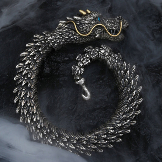 Nordic dragon copper alloy chain bracelet with sculpted dragon head turquoise eye gold horns and articulated scale body coiled on dark stone with atmospheric smoke