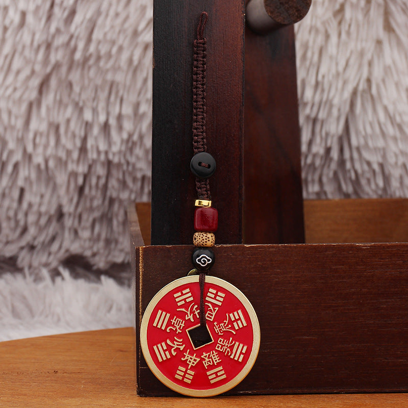 Shan Gui Keychain – bagua trigram design facing front, hanging on dark wood rack, auspicious cord