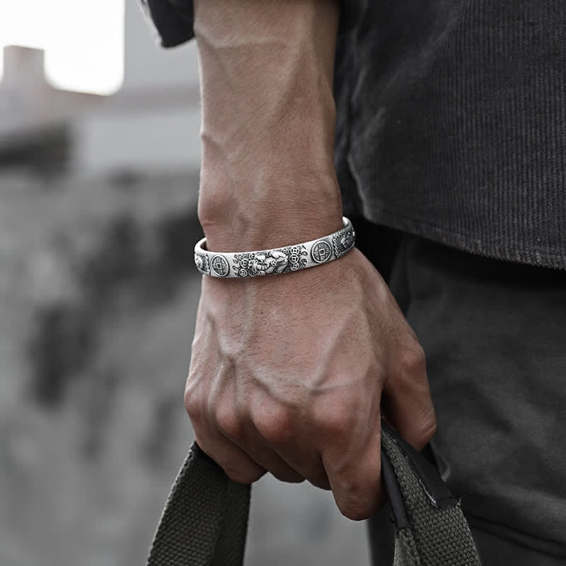 Men's silver Pixiu cuff bracelet with engraved mythical beast and coin patterns worn on wrist, urban lifestyle feng shui jewelry
