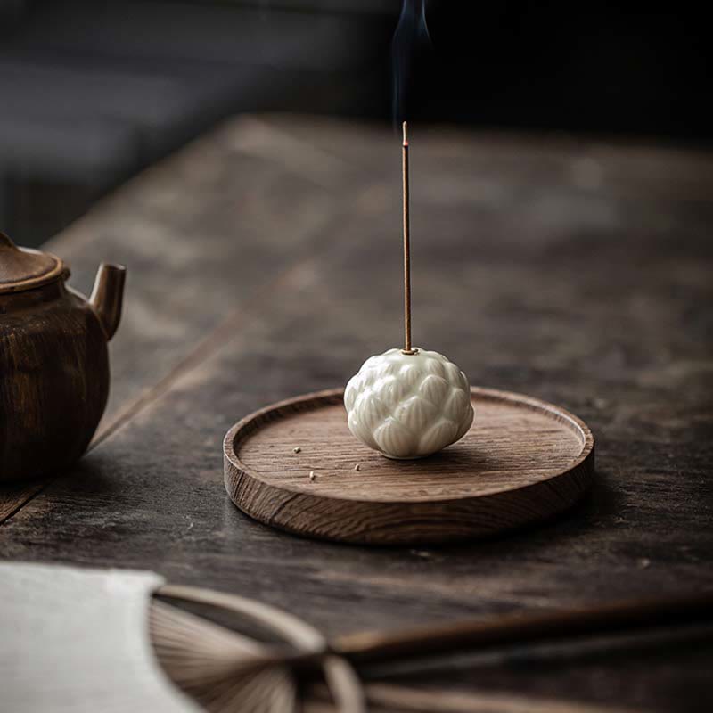 Ceramic Lotus Incense Burner on aged wooden table with teapot, artisan zen decor