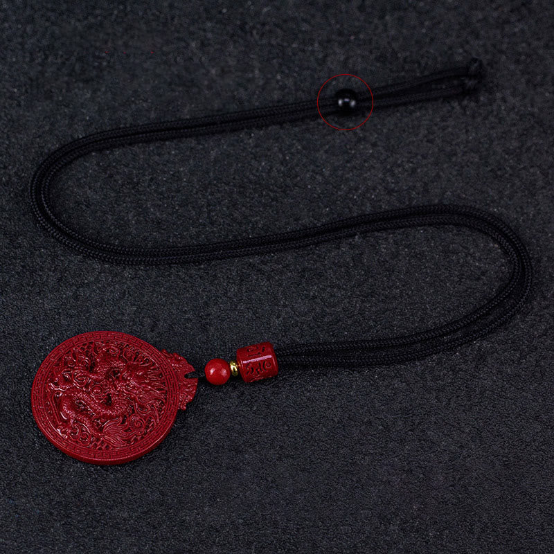Cinnabar Dragon Pendant – Flat lay of carved dragon amulet with adjustable black cord, Wearable