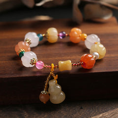 Golden Silk Jade Gourd Bracelet – Colorful jade beads with gourd charm on dark wood