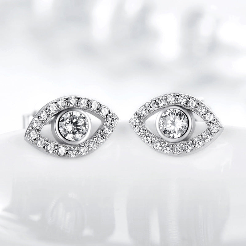 Sterling Silver Evil Eye Stud Earrings on Reflective White Surface, Clear Crystal Eye Design