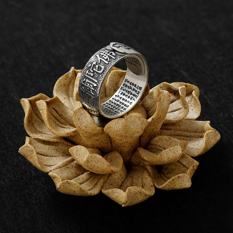 Natal Buddha Ring - Silver ring on ceramic lotus stand dark background, Enlightened