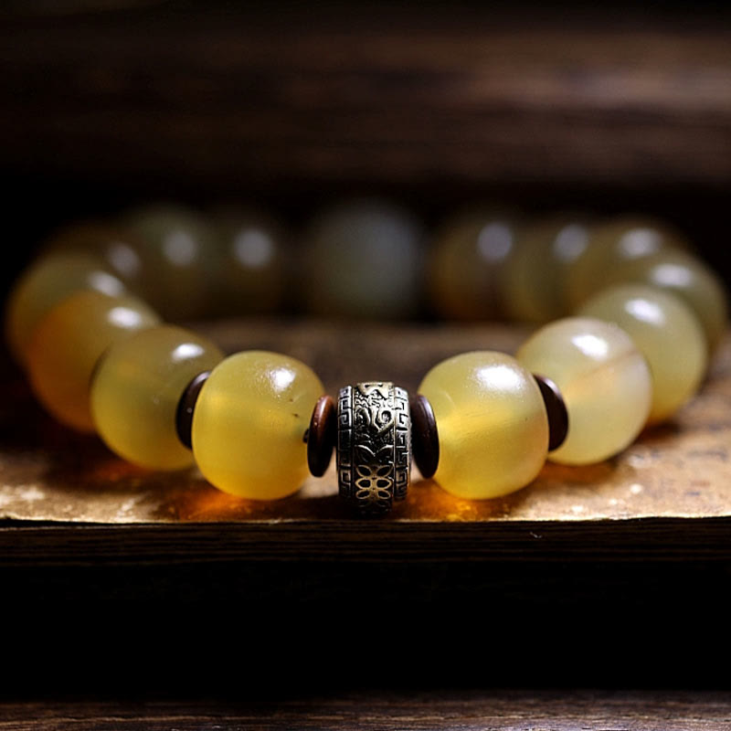 Tibetan Sheep Horn Skull Bracelet – Close-up of antiqued metal charm with floral engraving between beads