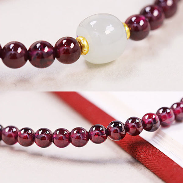 Garnet jade bracelet detail shots showing central jade focal bead with gold spacers on white satin, and strand on red fabric pouch, close-up macro views