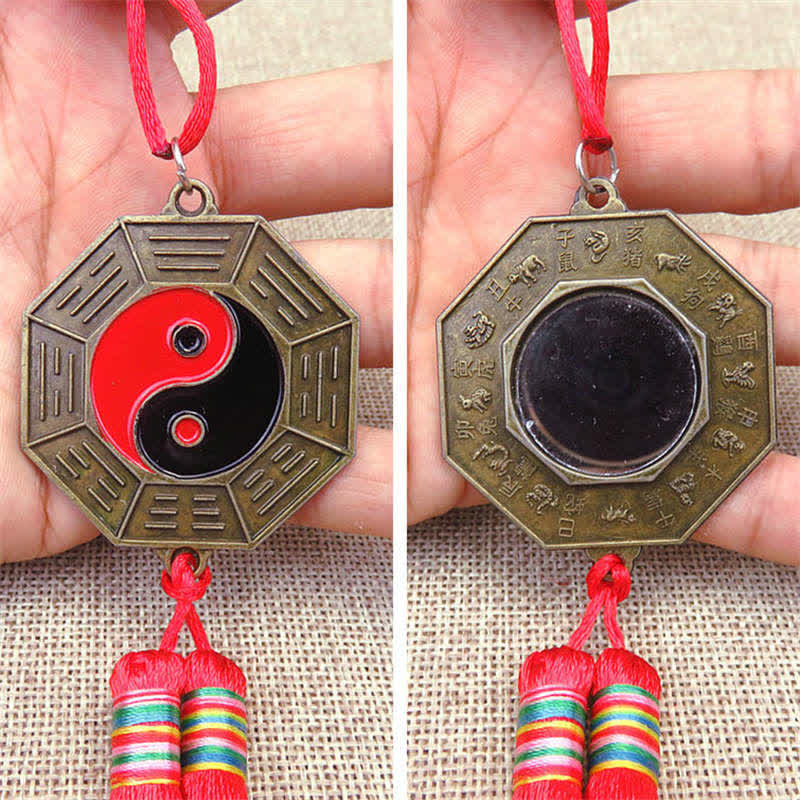 Feng Shui Bagua Map Mirror - Bronze bagua mirror pendant with yin-yang, eight trigrams, zodiac animals and red tassels held .