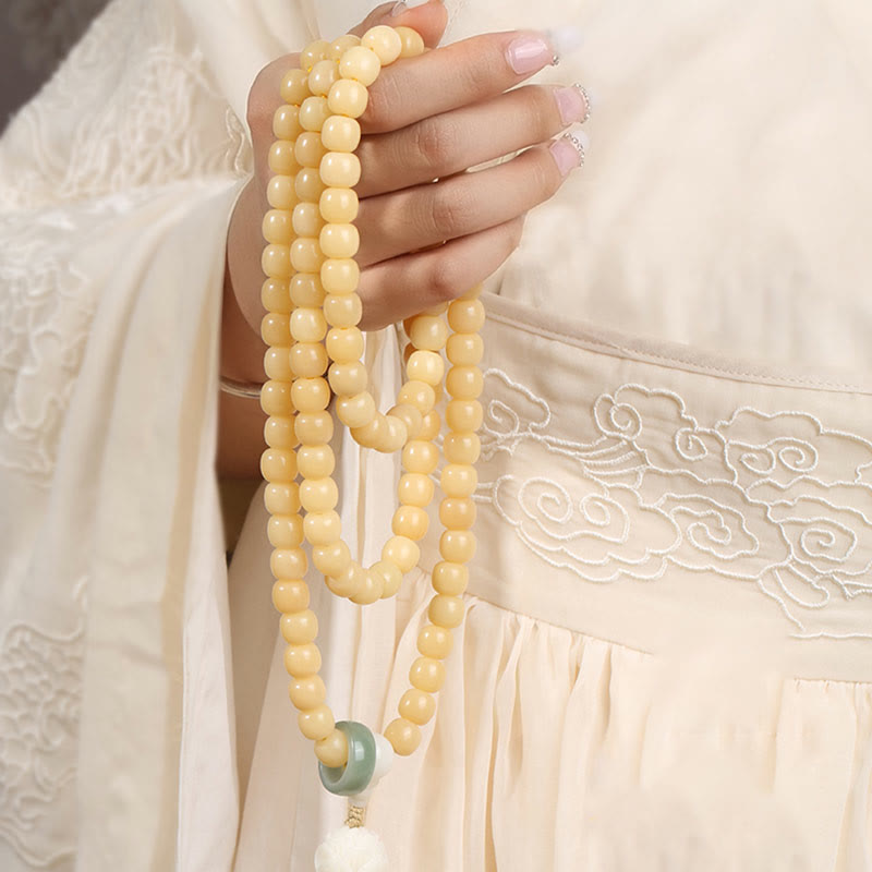 Bodhi Seed Lotus Dzi Bracelet - Cream bodhi strands draped through fingers on embroidered hanfu, prayer beads