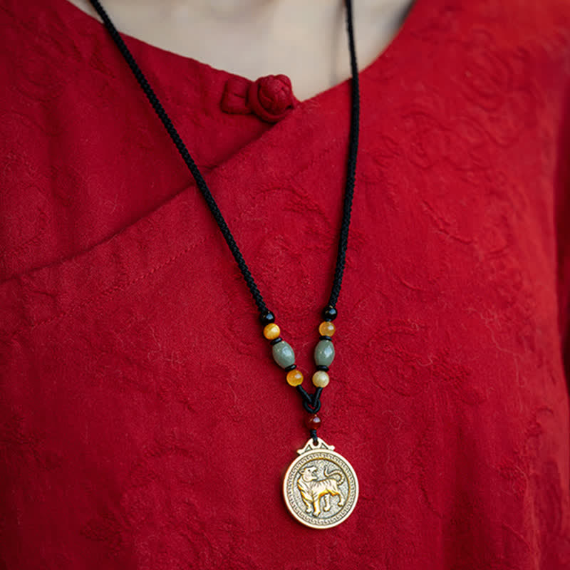 12 Chinese Zodiac Fortune Necklace Pendant – Tiger zodiac necklace worn on red silk garment with mandarin collar and frog button, antique gold tiger medallion with meander border, jade and carnelian beaded black cord, traditional Chinese cultural styling