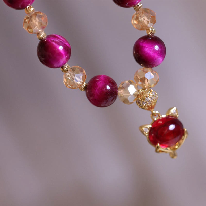 Red Tiger Eye Fox Bracelet – Close-up of gold fox pendant with red gem against gray background