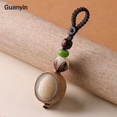Bodhi Seed Blessing Keychain - Guanyin head carving nestled inside natural seed pod with silver inlay cloud bead, compassion